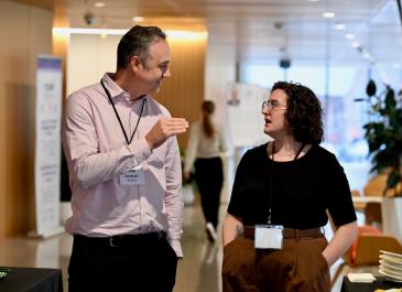 Attendees having a discussion in the foyer during a break
