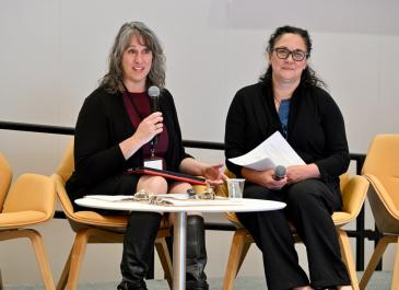 Joanna Goode and Mary Beshai on stage speaking