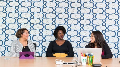 three women sitting together behind a table