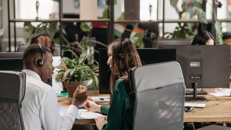 Diverse call center agents collaborating in a modern office environment