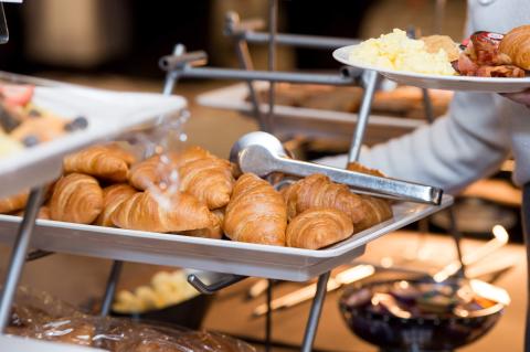 A plate of croissants displayed on a food table.