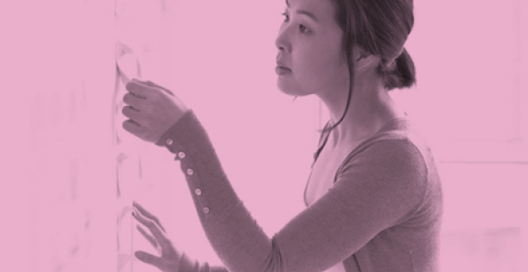 A woman looking at document on a board