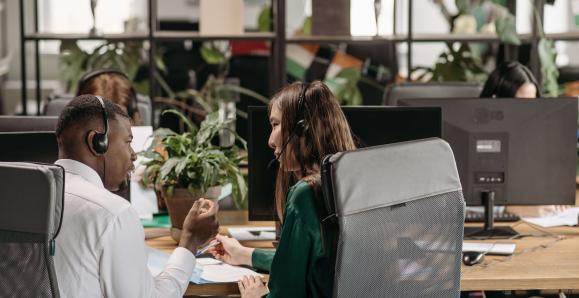 Diverse call center agents collaborating in a modern office environment